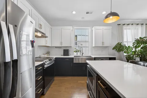 a kitchen with a sink a counter top space stainless steel appliances and cabinets