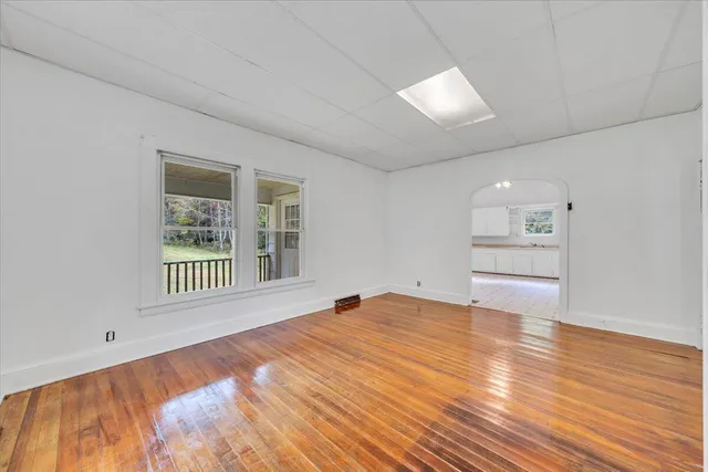 an empty room with wooden floor and window