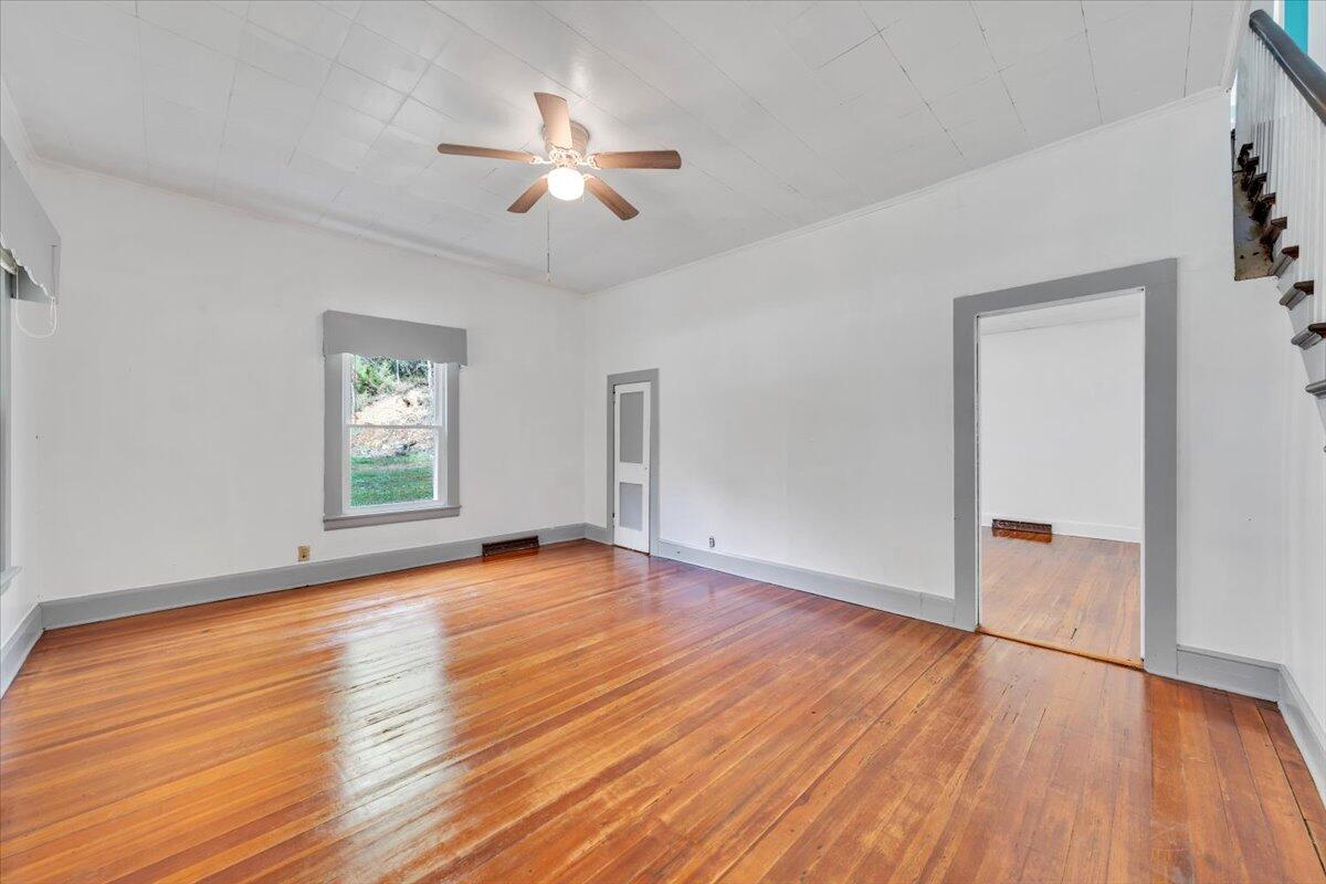 6973 Henry Road Henry, VA 24102 - Photo 3 of 110 an empty room with wooden floor chandelier and windows
