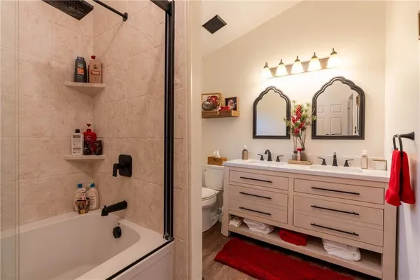 a bathroom with a tub sink and mirror