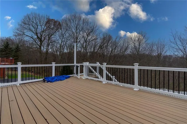 a view of a balcony with wooden floor and fence