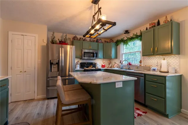 a kitchen with stainless steel appliances granite countertop a sink a stove and a refrigerator