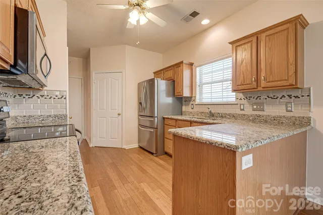 a kitchen with stainless steel appliances granite countertop a sink stove and refrigerator