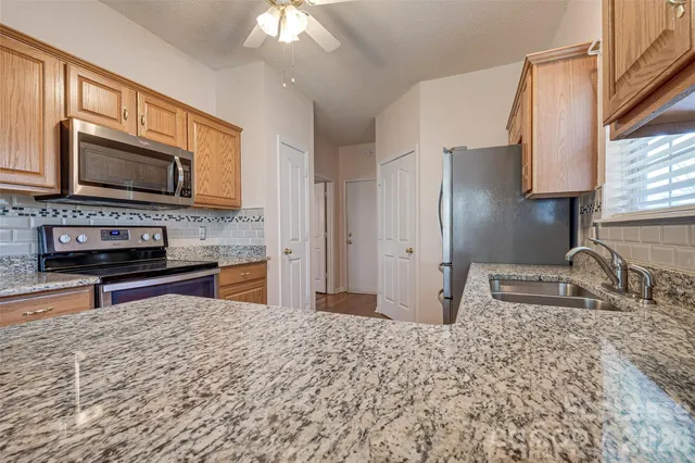 a kitchen with stainless steel appliances granite countertop a sink stove and refrigerator