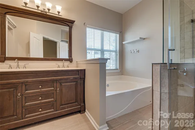 a bathroom with a tub sink and mirror