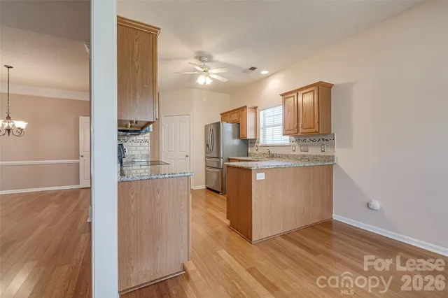 a kitchen with stainless steel appliances granite countertop a refrigerator a sink and a stove