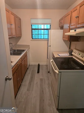 a kitchen that has a sink and wooden floor