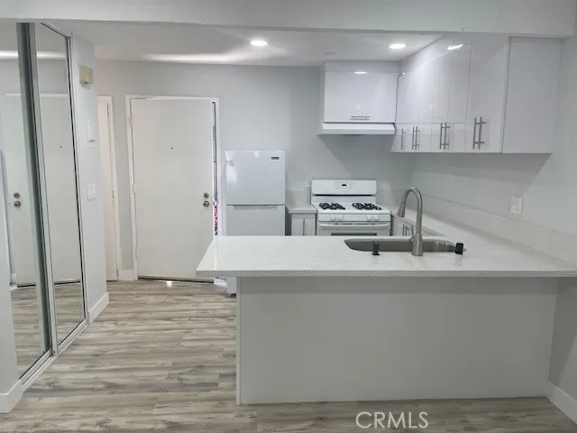 a kitchen with kitchen island sink stove and cabinets