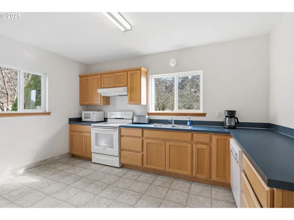 a kitchen with a sink cabinets appliances and a window