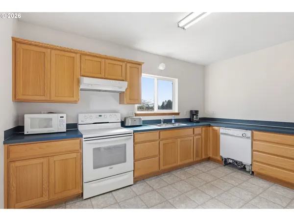 a kitchen with granite countertop cabinets stainless steel appliances a sink and a window