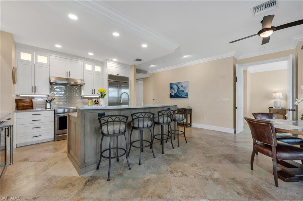780 5th Avenue South, Unit 302 Naples, FL 34102 - Photo 5 of 20 a kitchen with cabinets and chairs