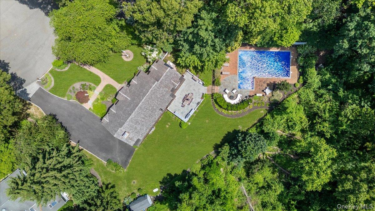 5 Fox Hunt Court Cold Spring Harbor, NY 11724 - Photo 37 of 42 Expansive property featuring an L-shaped swimming pool, brick pool deck, and a large stone patio