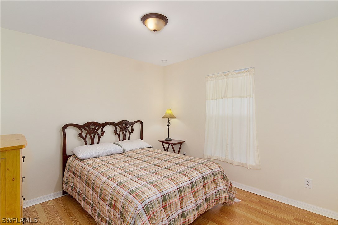 3002 52nd Street West Lehigh Acres, FL 33971 - Photo 12 of 18 a bedroom with a bed and wooden floor