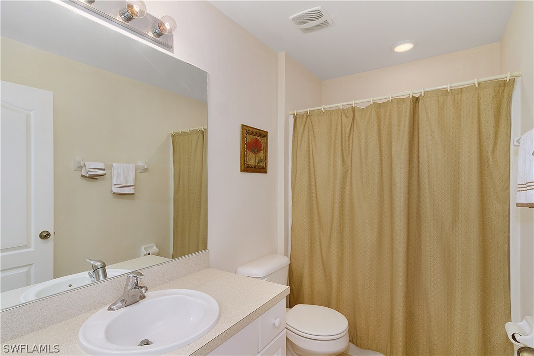 3002 52nd Street West Lehigh Acres, FL 33971 - Photo 13 of 18 a bathroom with a sink a toilet and shower curtain
