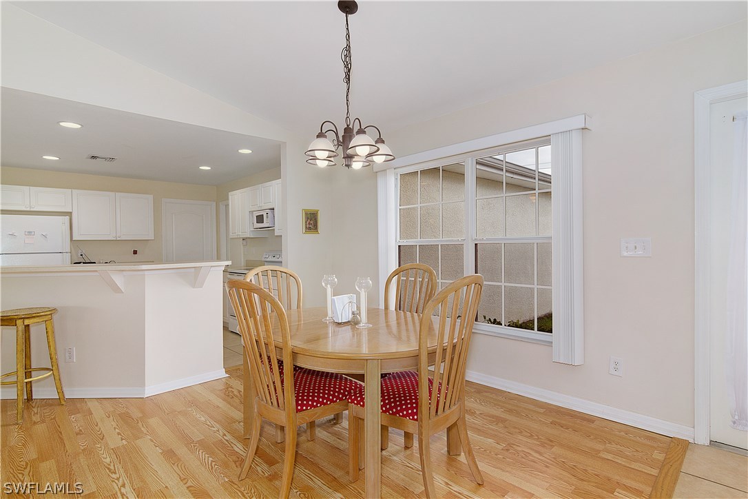 3002 52nd Street West Lehigh Acres, FL 33971 - Photo 6 of 18 a view of a dining room with furniture and wooden floor