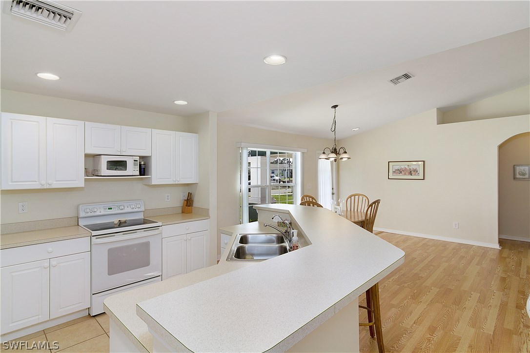 3002 52nd Street West Lehigh Acres, FL 33971 - Photo 8 of 18 a kitchen with a sink a stove and cabinets