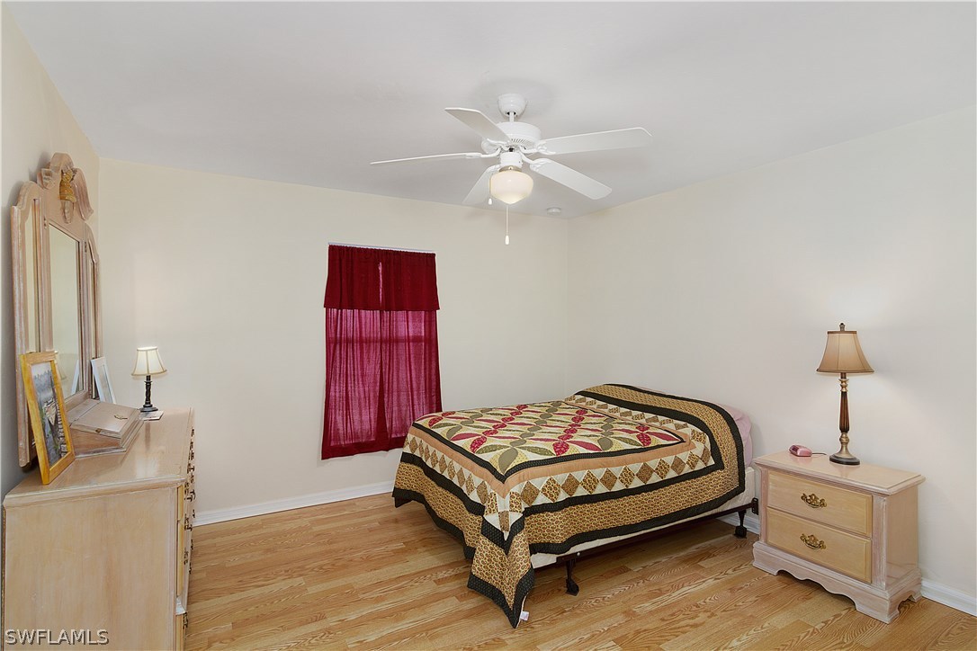 3002 52nd Street West Lehigh Acres, FL 33971 - Photo 10 of 18 a bedroom with a bed and a chandelier