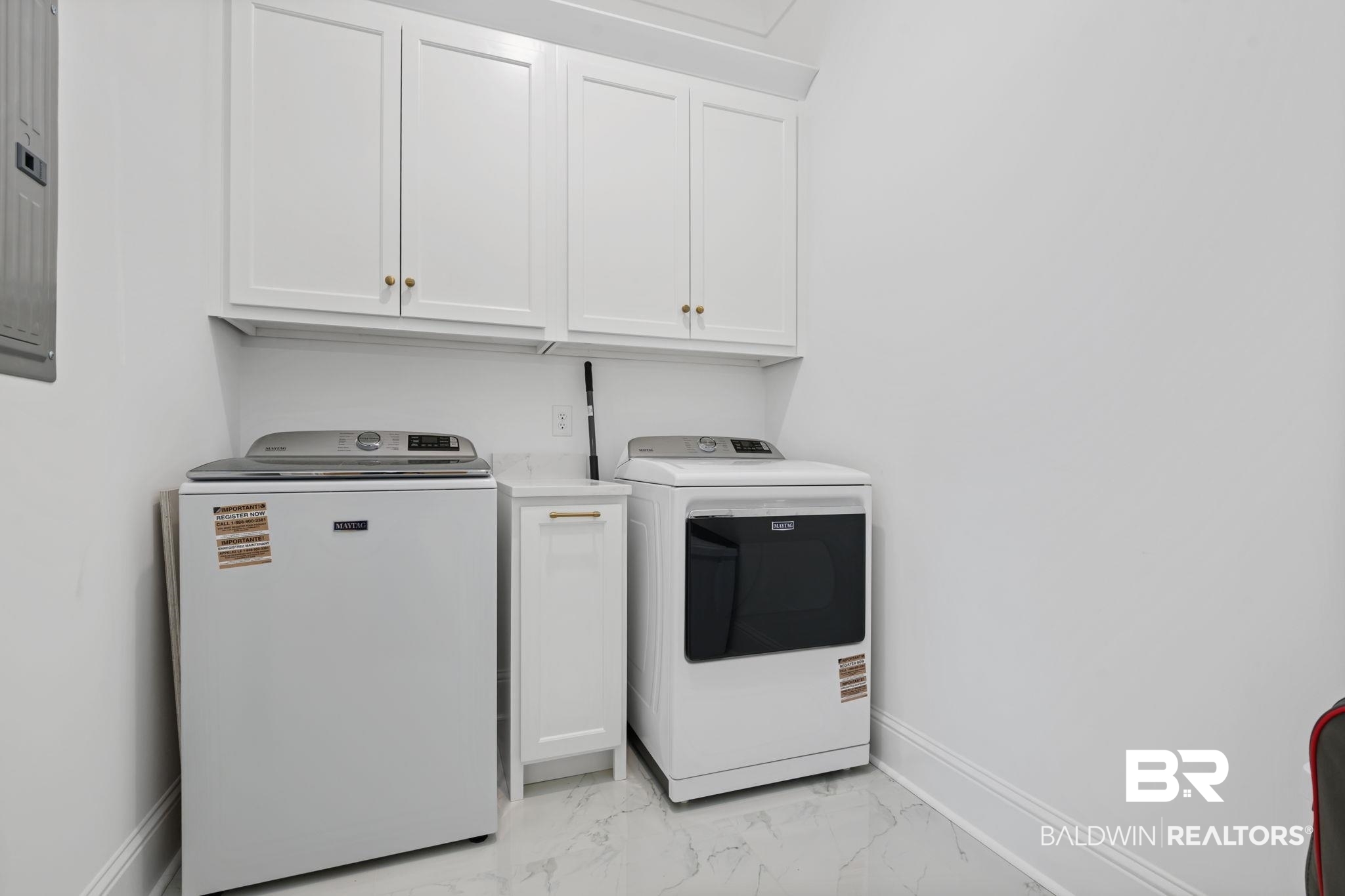 30313 River Road Orange Beach, AL 36561 - Photo 37 of 50 Washroom with cabinet space, light marble finish floors, washer and dryer, and electric panel