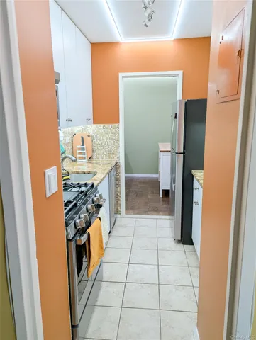 a kitchen with stainless steel appliances granite countertop a refrigerator and a stove