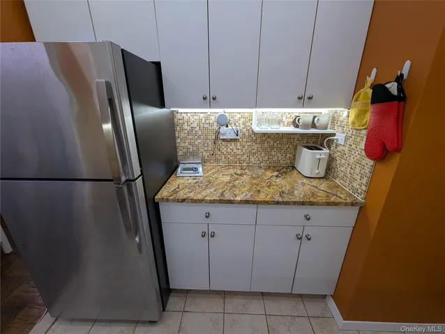 a kitchen with granite countertop a refrigerator and a sink