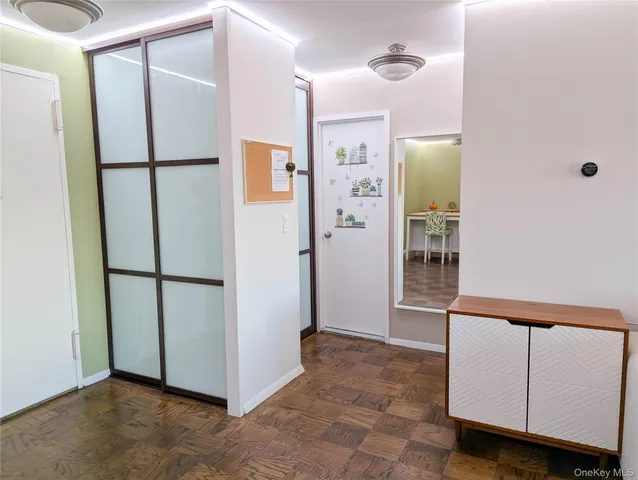 a view of a refrigerator in kitchen and an empty room