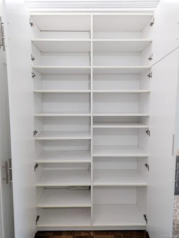 a view of walk in closet with empty racks