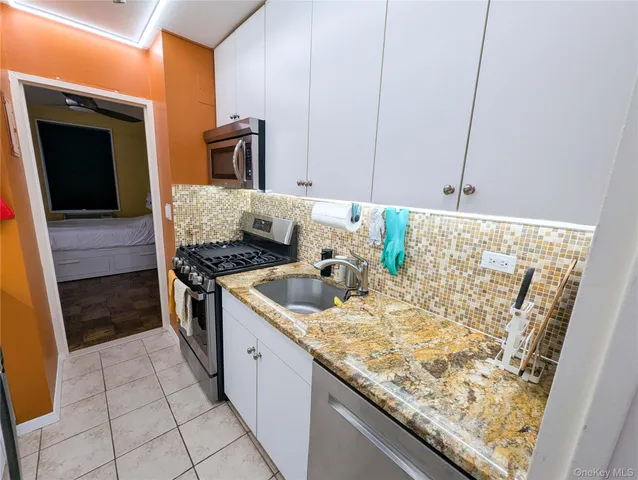 a kitchen with granite countertop a sink and a stove top oven