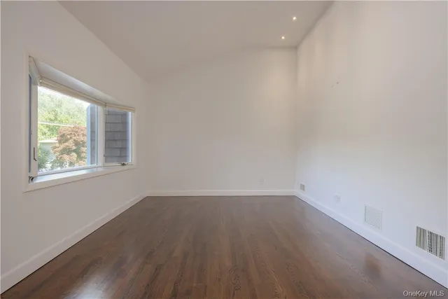 an open kitchen with wooden floor and windows