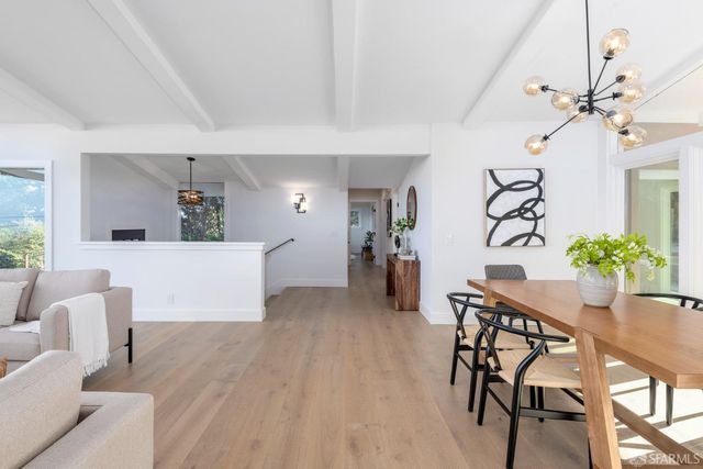 a kitchen with stainless steel appliances a stove a sink dishwasher a oven with white cabinets and wooden floor