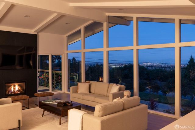 a living room with furniture a floor to ceiling window and a flat screen tv