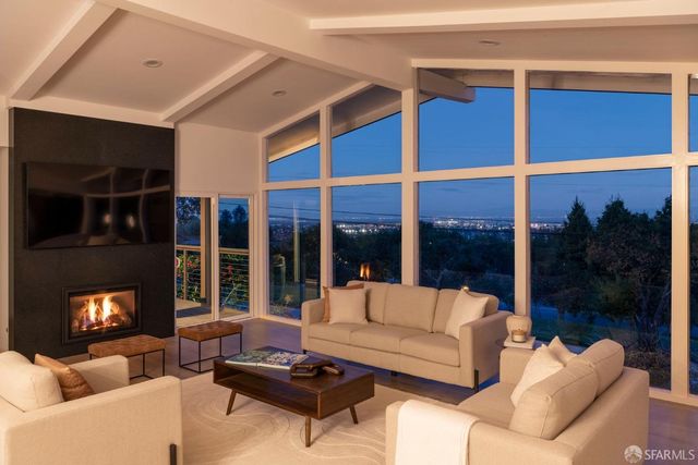 a living room with furniture a floor to ceiling window and a flat screen tv