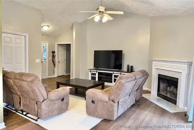 a living room with furniture a fireplace and a flat screen tv