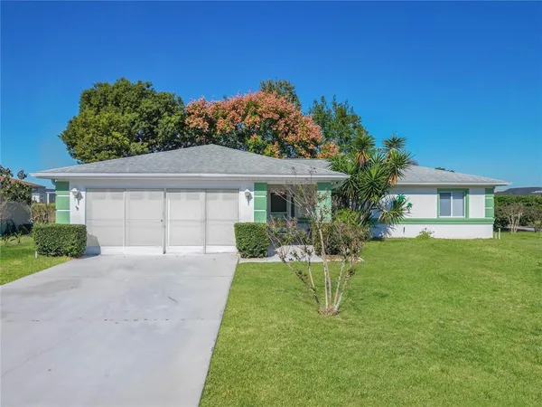 a front view of a house with a yard and trees