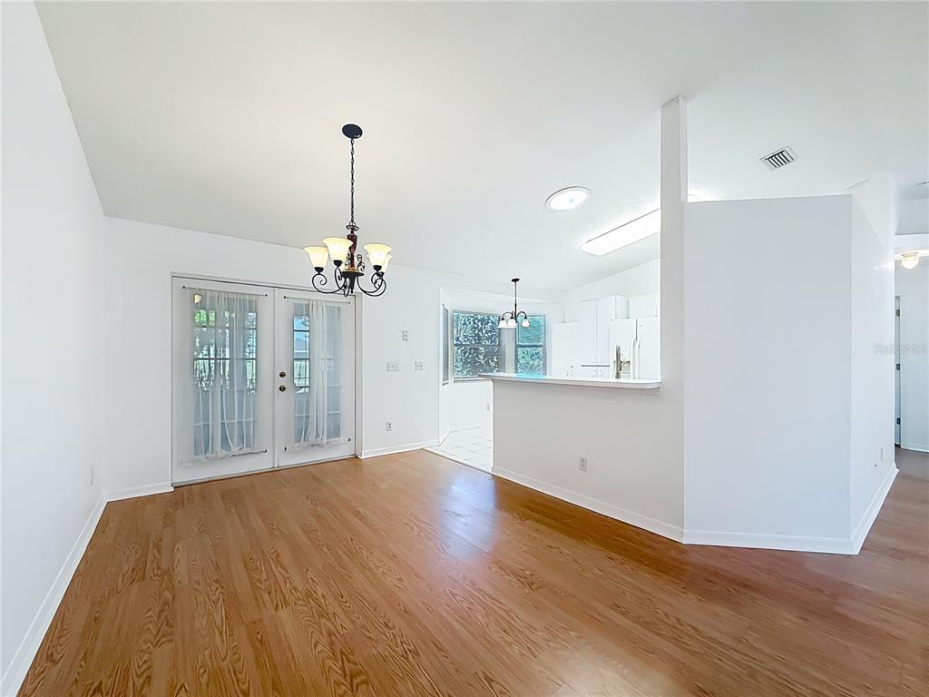 6175 Southwest 98th Loop Ocala, FL 34476 - Photo 11 of 56 a view of a room with wooden floor chandelier and a window