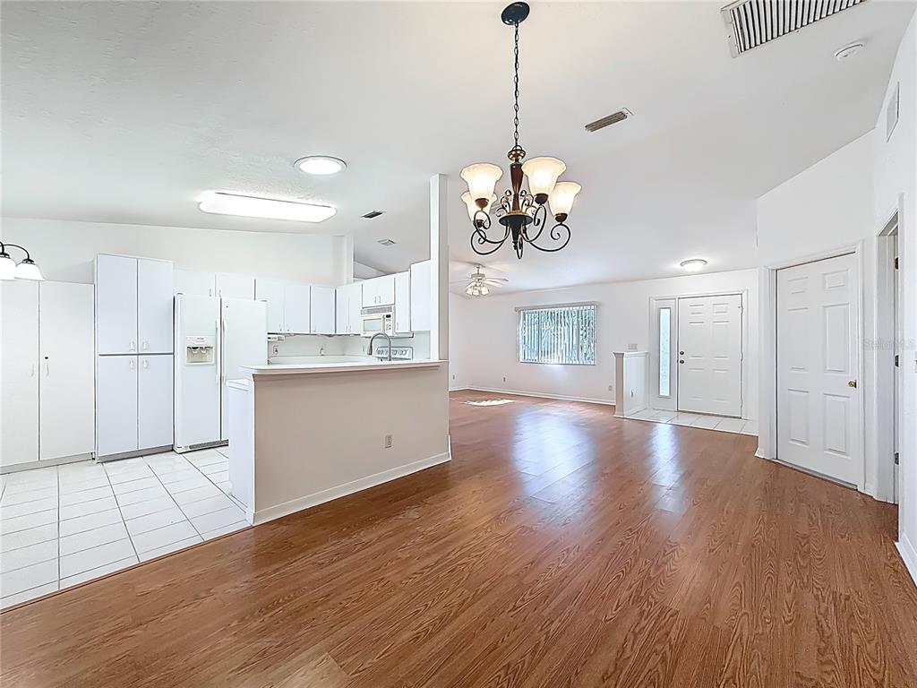 6175 Southwest 98th Loop Ocala, FL 34476 - Photo 12 of 56 a view of a kitchen with a sink dishwasher wooden floor and a large window