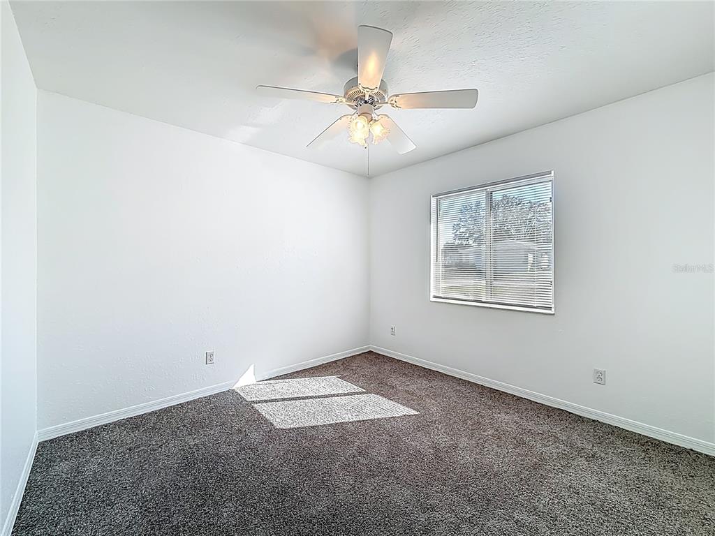 6175 Southwest 98th Loop Ocala, FL 34476 - Photo 25 of 56 an empty room with windows and fan