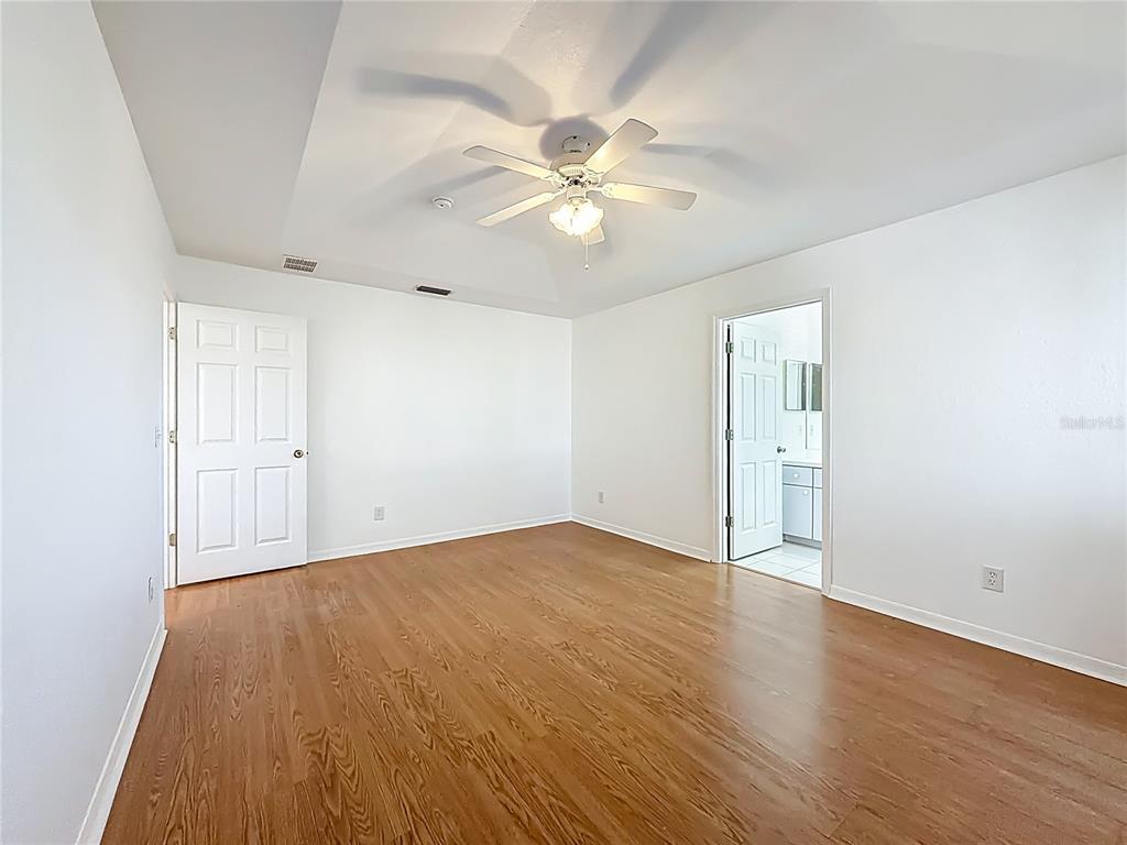 6175 Southwest 98th Loop Ocala, FL 34476 - Photo 32 of 56 an empty room with wooden floor fan and windows