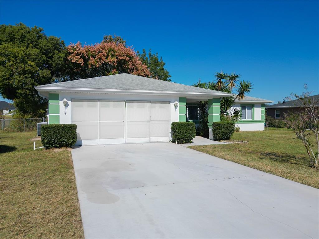 6175 Southwest 98th Loop Ocala, FL 34476 - Photo 49 of 56 a front view of a house with a yard and garage