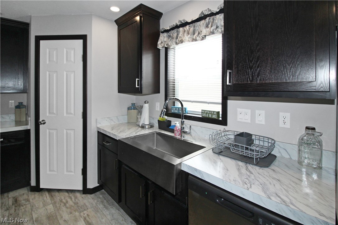1609 Coldwater Crossing Road Lakeside Marblehead, OH 43440 - Photo 24 of 38 Kitchen with dark brown cabinetry, sink, dishwasher, and light wood-type flooring