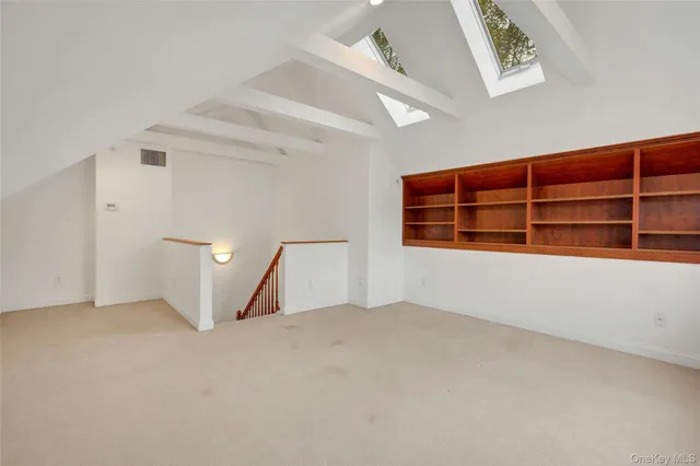 a view of an empty room with wooden floor and windows