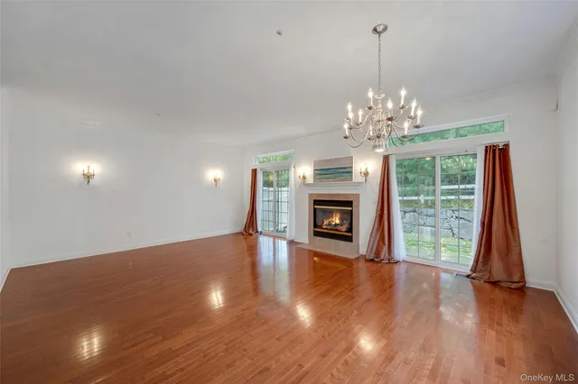 a view of a room with wooden floor chandelier and windows