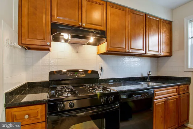 a stove top oven sitting inside of a kitchen