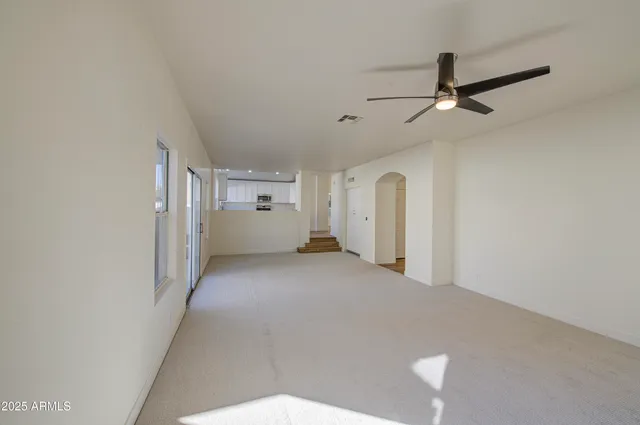 a view of a big room with entryway and chandelier fan
