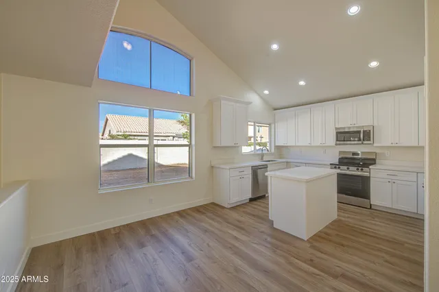 a kitchen with a white cabinets wooden floor and a sink