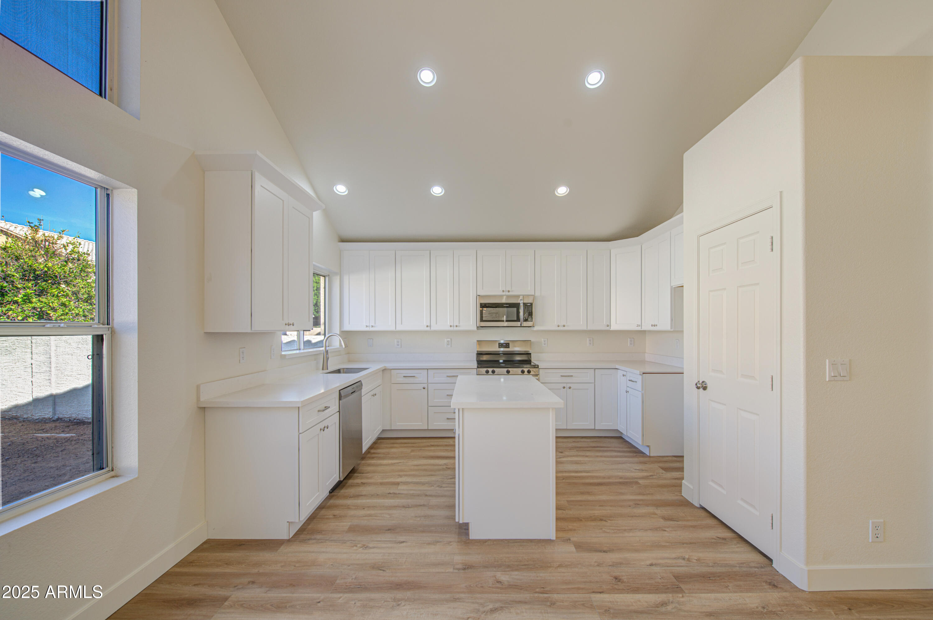 4266 East Millbrae Lane Gilbert, AZ 85234 - Photo 15 of 53 a large white kitchen with wooden floor and stainless steel appliances