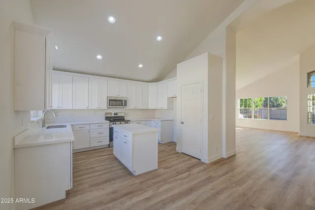 a kitchen with a sink cabinets and wooden floor