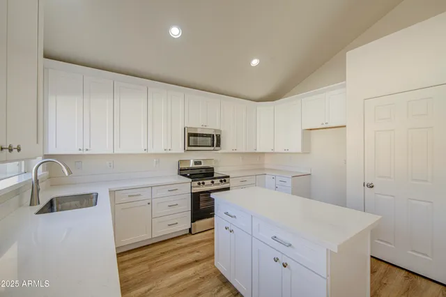 a kitchen with stainless steel appliances a white stove top oven sink and cabinets