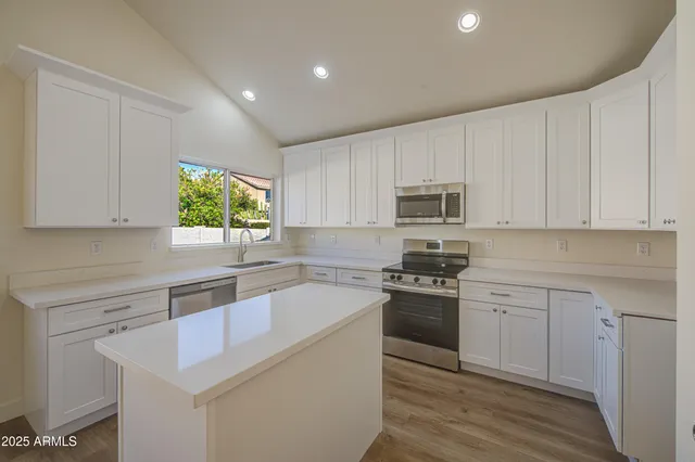 a kitchen with granite countertop white cabinets and white appliances