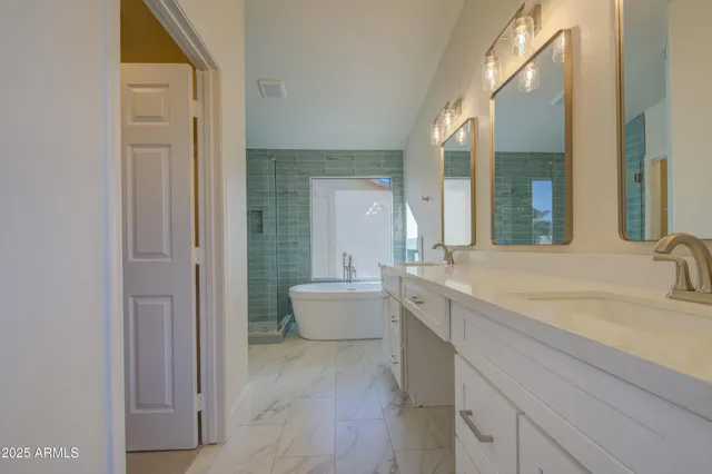 a bathroom with a double vanity sink mirror and bathtub