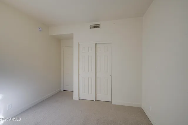 an empty room with windows and fan